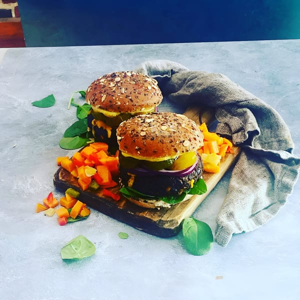 Two Scrum-did-dly-ump-tious breakfast burgers with seeded buns, spinach, and diced vegetables.