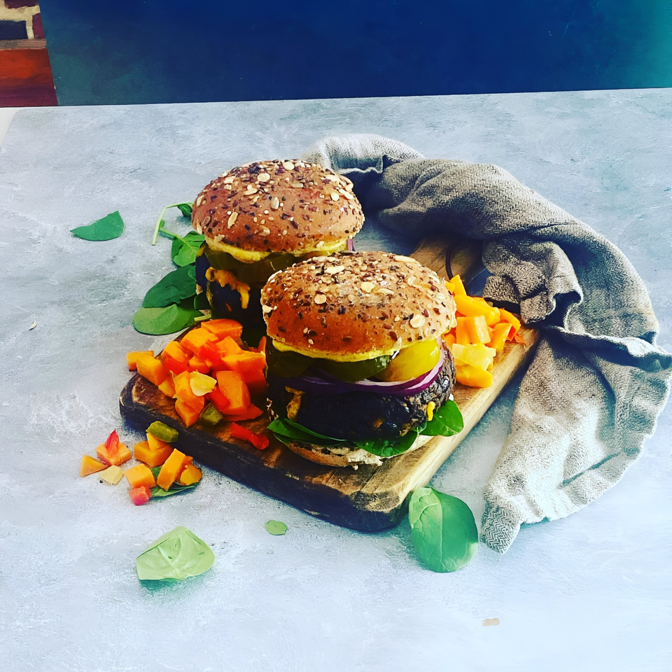 Two Scrum-did-dly-ump-tious breakfast burgers with seeded buns, spinach, and diced vegetables.